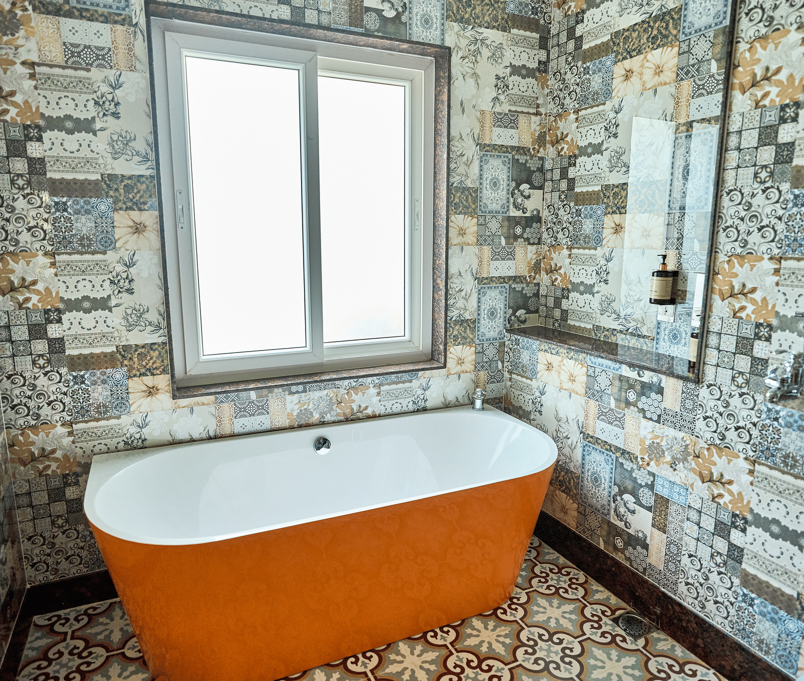 A bathtub with a sliding window behind it at Mayfair Manor, Alibag