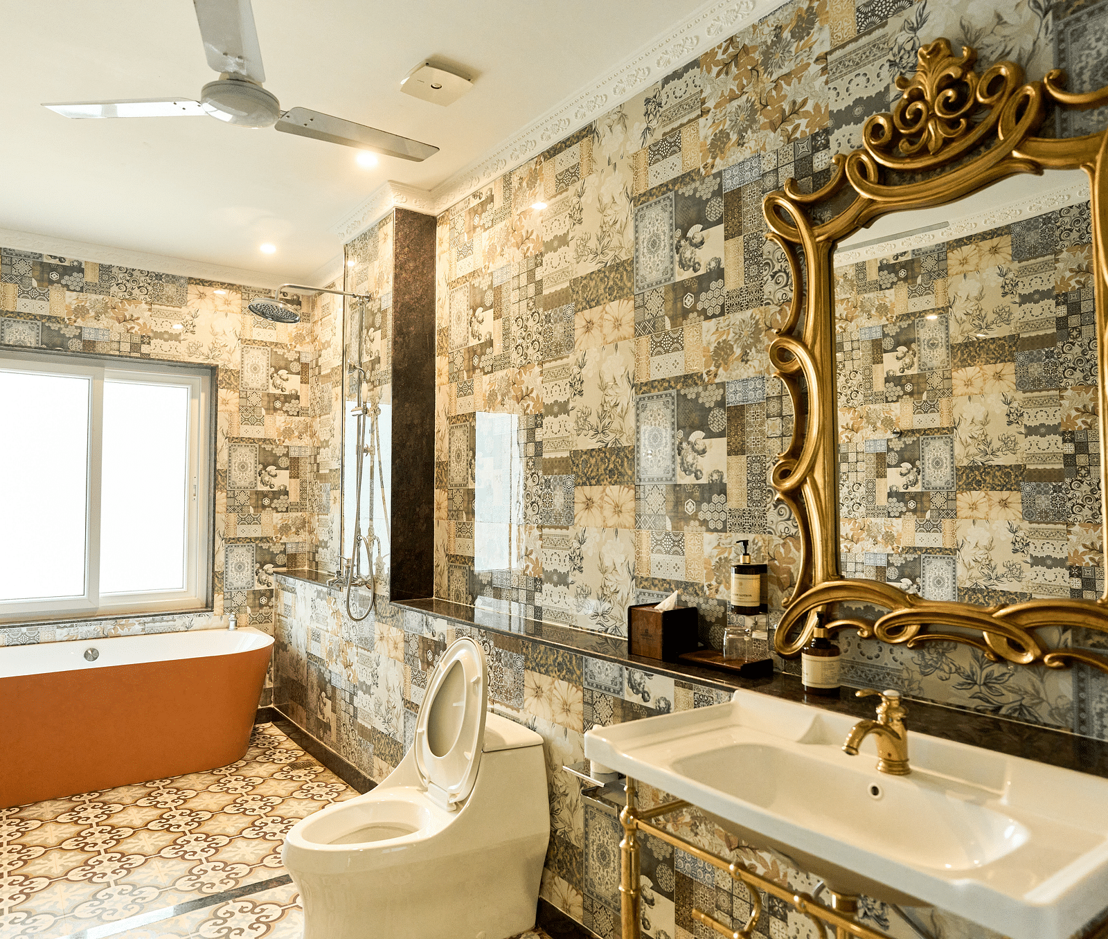 A spacious bathroom with a bathtub, Western toilet, and a washbasin with a wall-mounted mirror above it at Mayfair Manor, Alibag