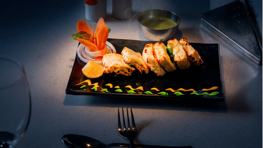 Char-grilled creamy tikka slices with sauce squiggles, a carrot fan, onion rings and lemon at Tandoori Tamashaa restaurant, Ilara Hotels & Spa, Tada.