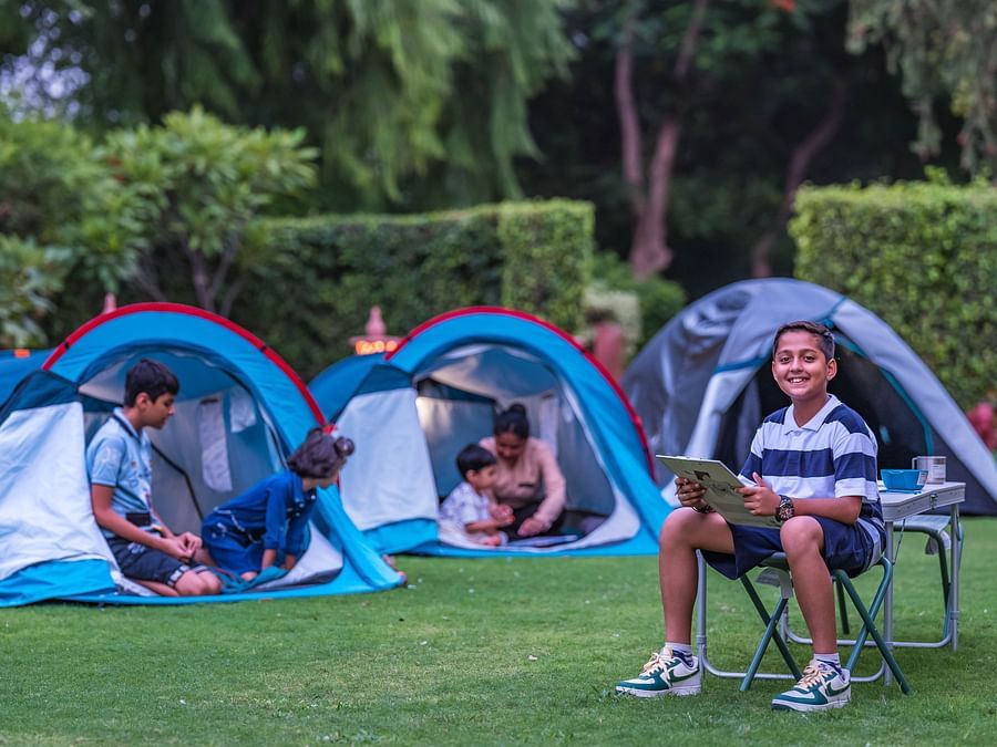 children playing in tents in the lush garden at Heritage Village Resort & Spa, Manesar