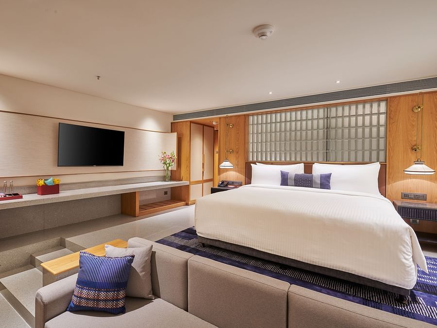 Image of a bedroom with a television, king side bed and a foot sofa in front of the bed  at The Dukes Retreat.