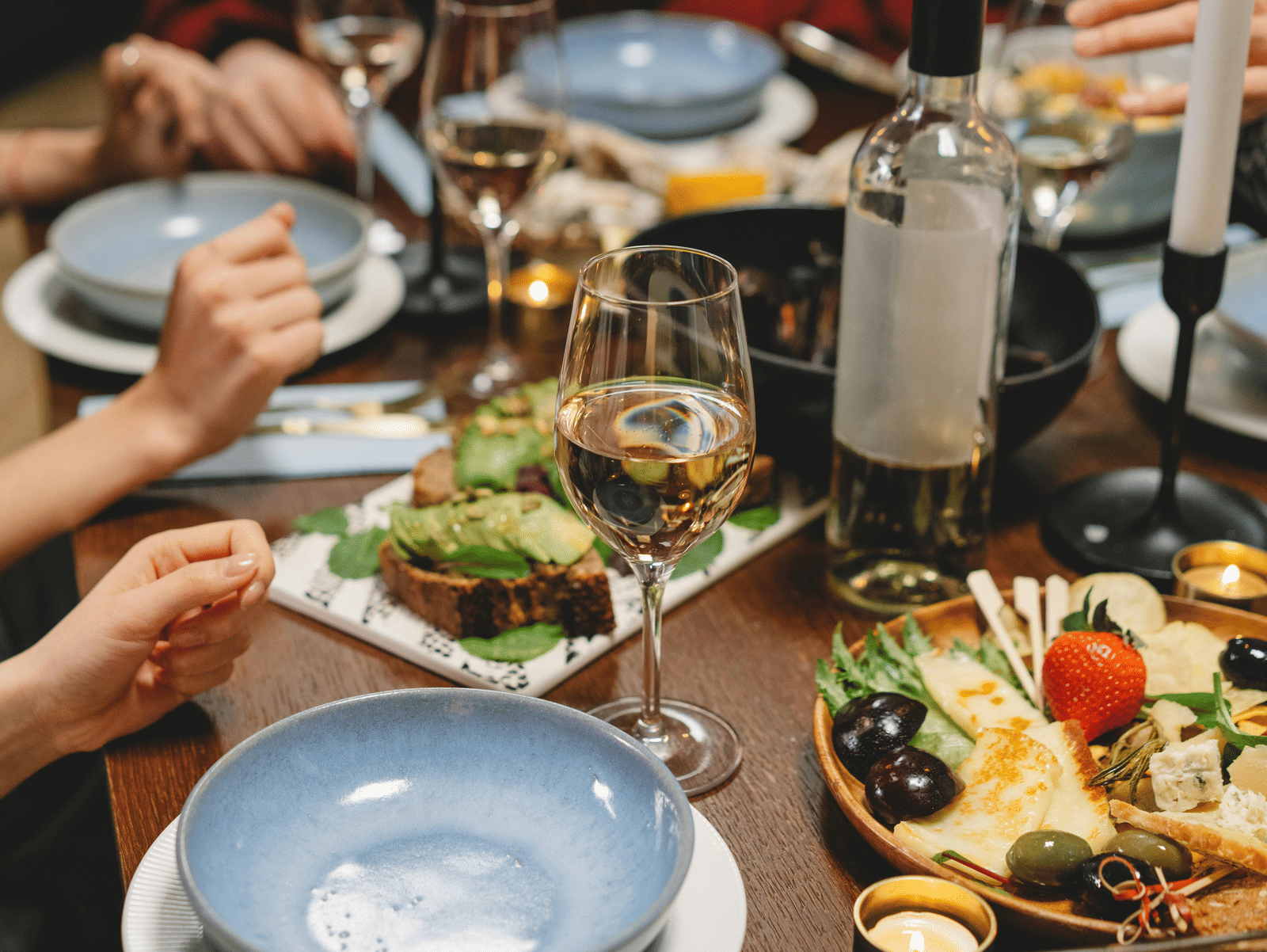 Guests enjoying wine, cheese, and gourmet dishes, during an elegant dining experience.