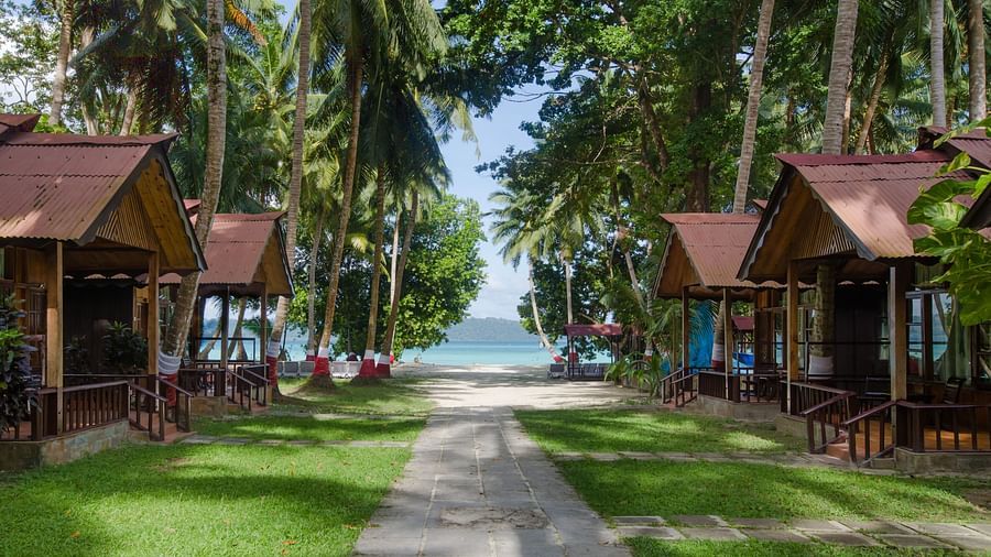 Pathway leading to beach with wooden cottages on either side