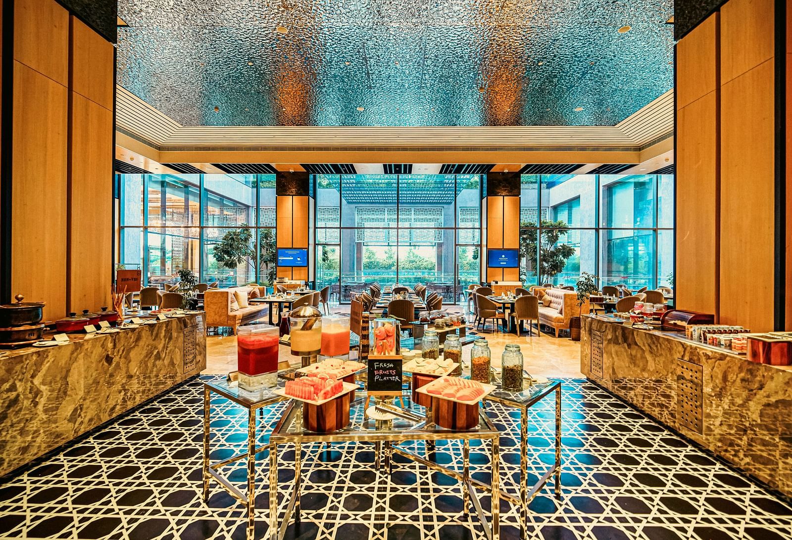 A vibrant buffet setup with fresh juices and fruit platters, framed by sleek and elegant decor