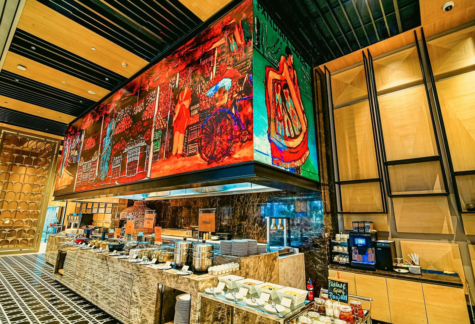 A colourful live station in the restaurant featuring artistic murals and a wide selection of food