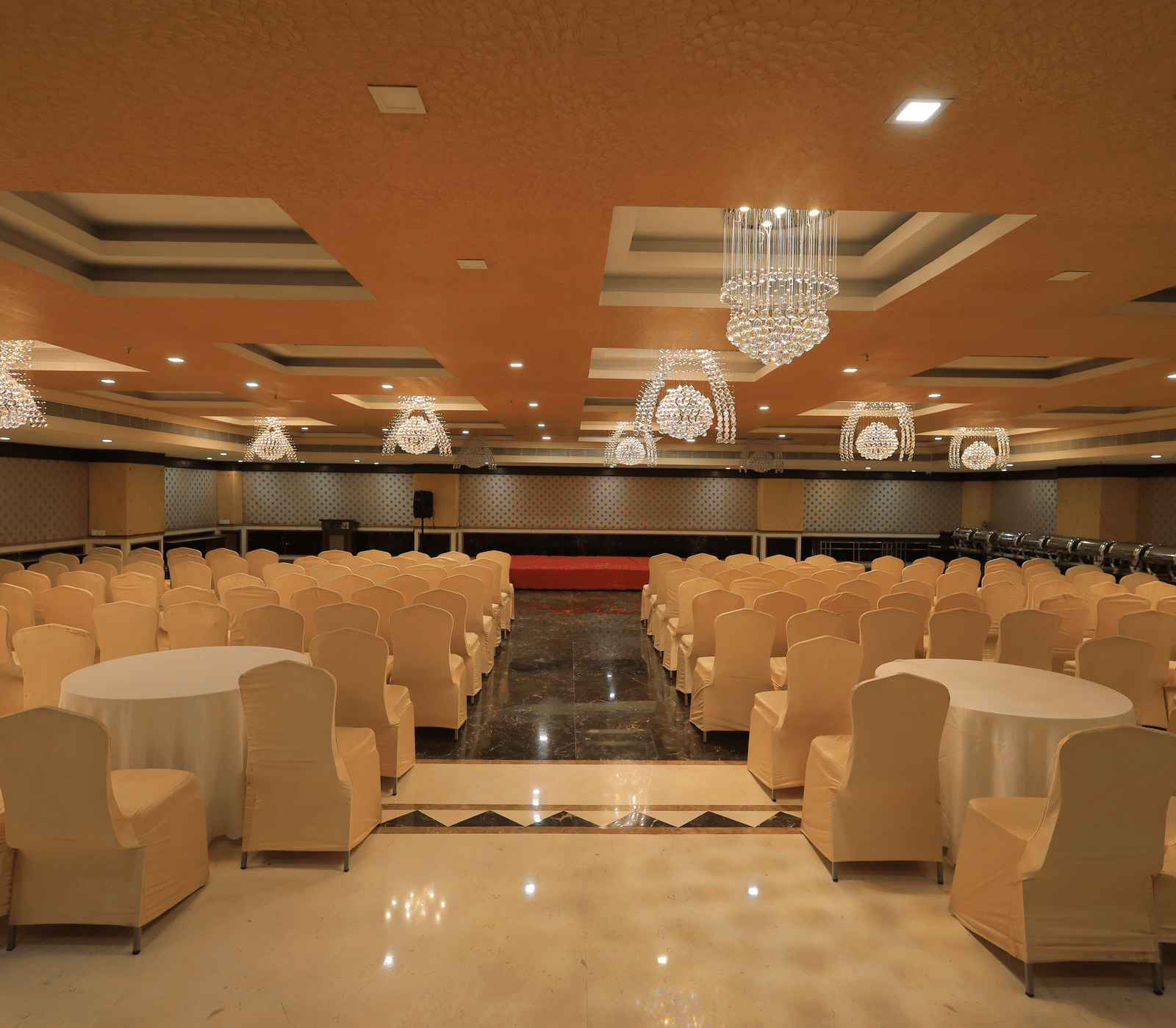 A wide-angle shot of the Rovver hall at Benzz Park, Vellore, with chairs facing towards the centre stage.