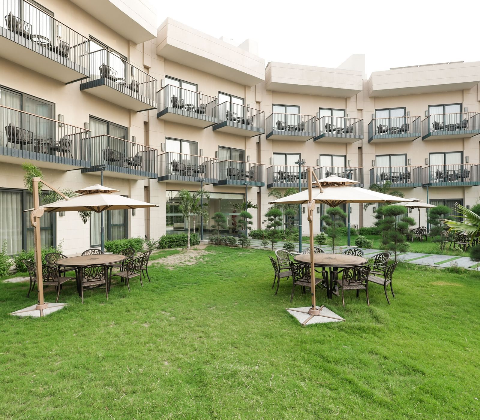 Green garden area with cabana-style seating at Ramada by Wyndham Sonipat Murthal