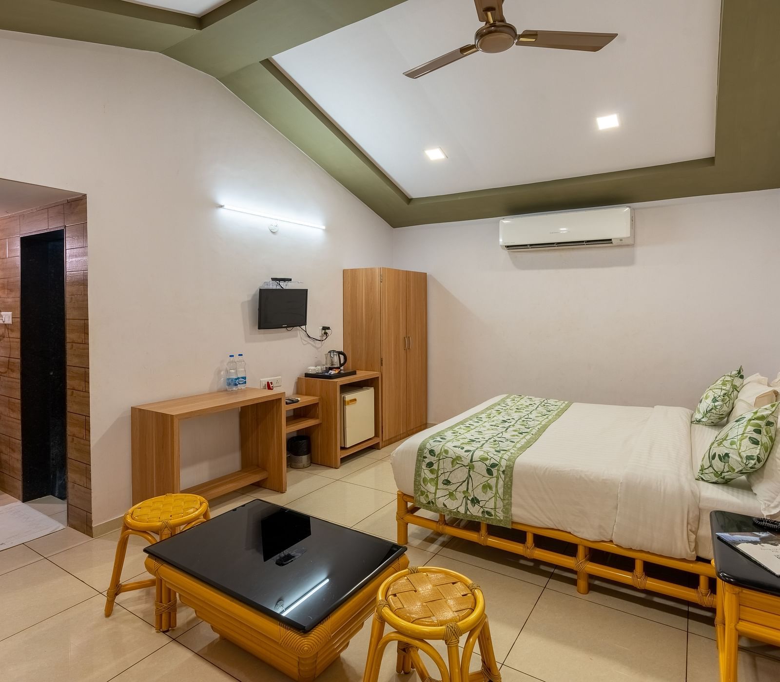 A room with a double bed, seating arrangement and work desk and chair