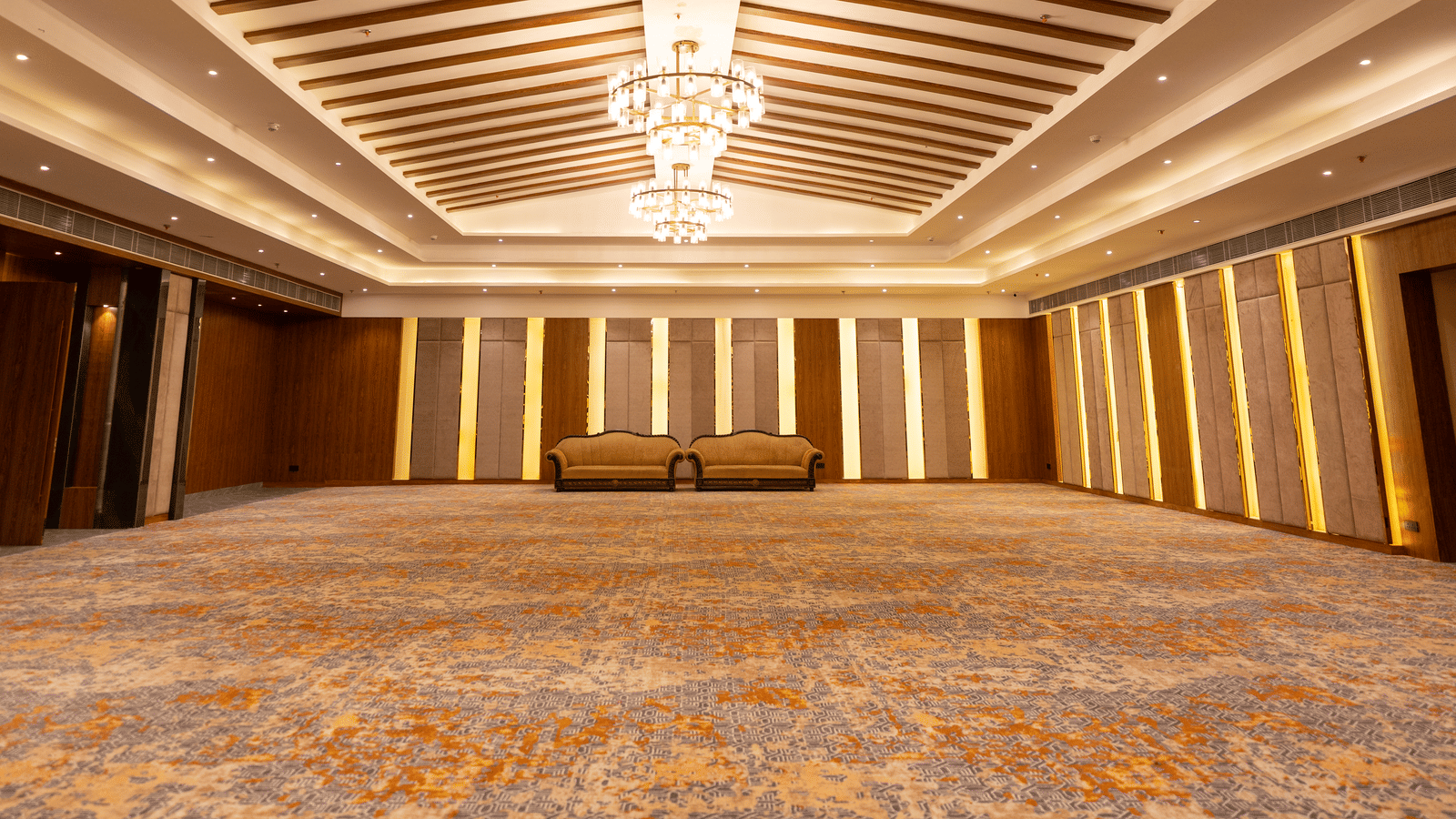 An expansive banquet hall at Wyndham Garden featuring a central chandelier and a spacious setup.