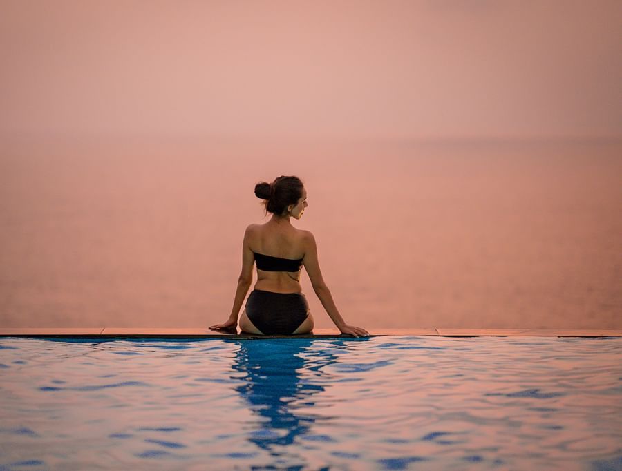 a woman relaxing in the infinity pool at cintacor island resort