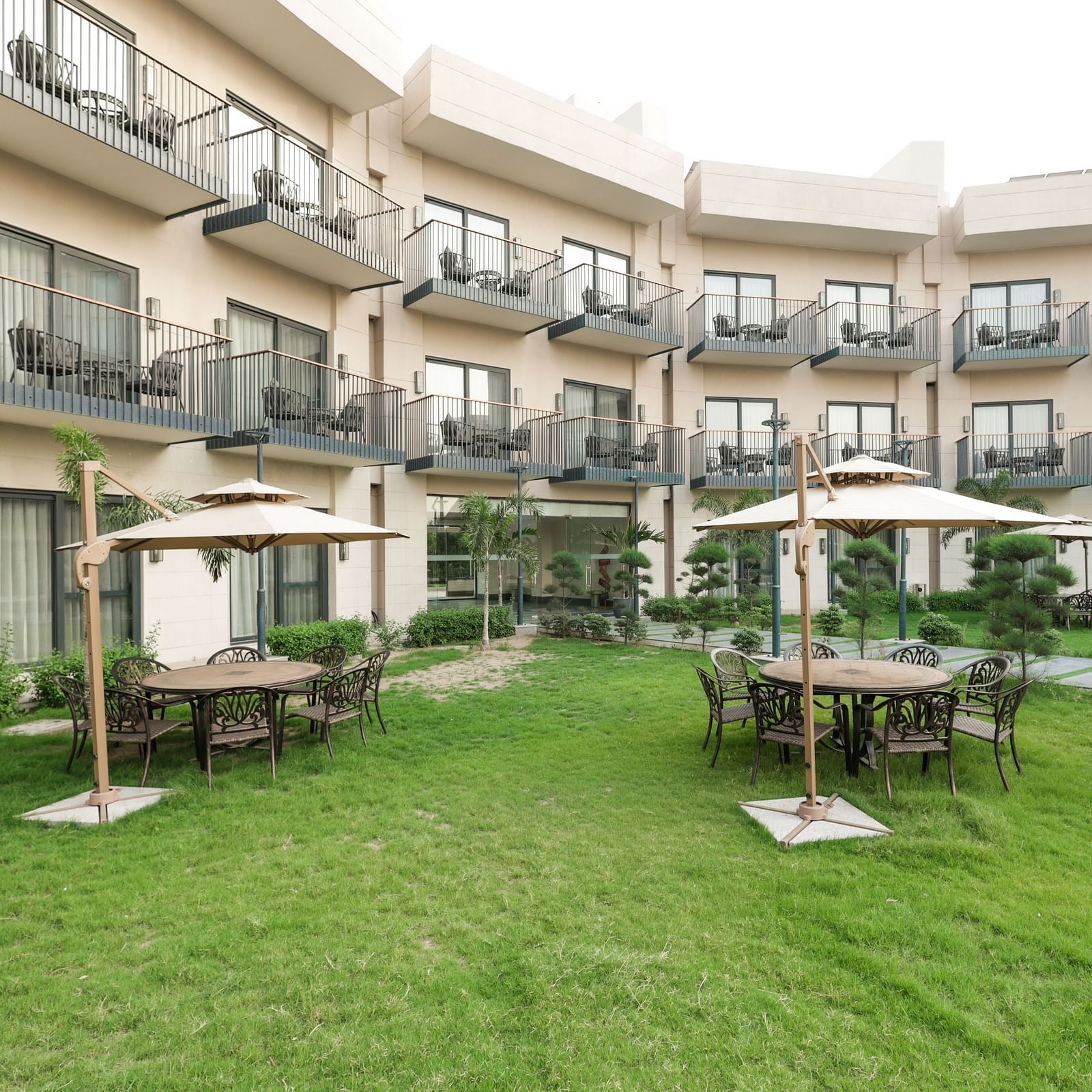 Green garden area with cabana-style seating at Ramada by Wyndham Sonipat Murthal