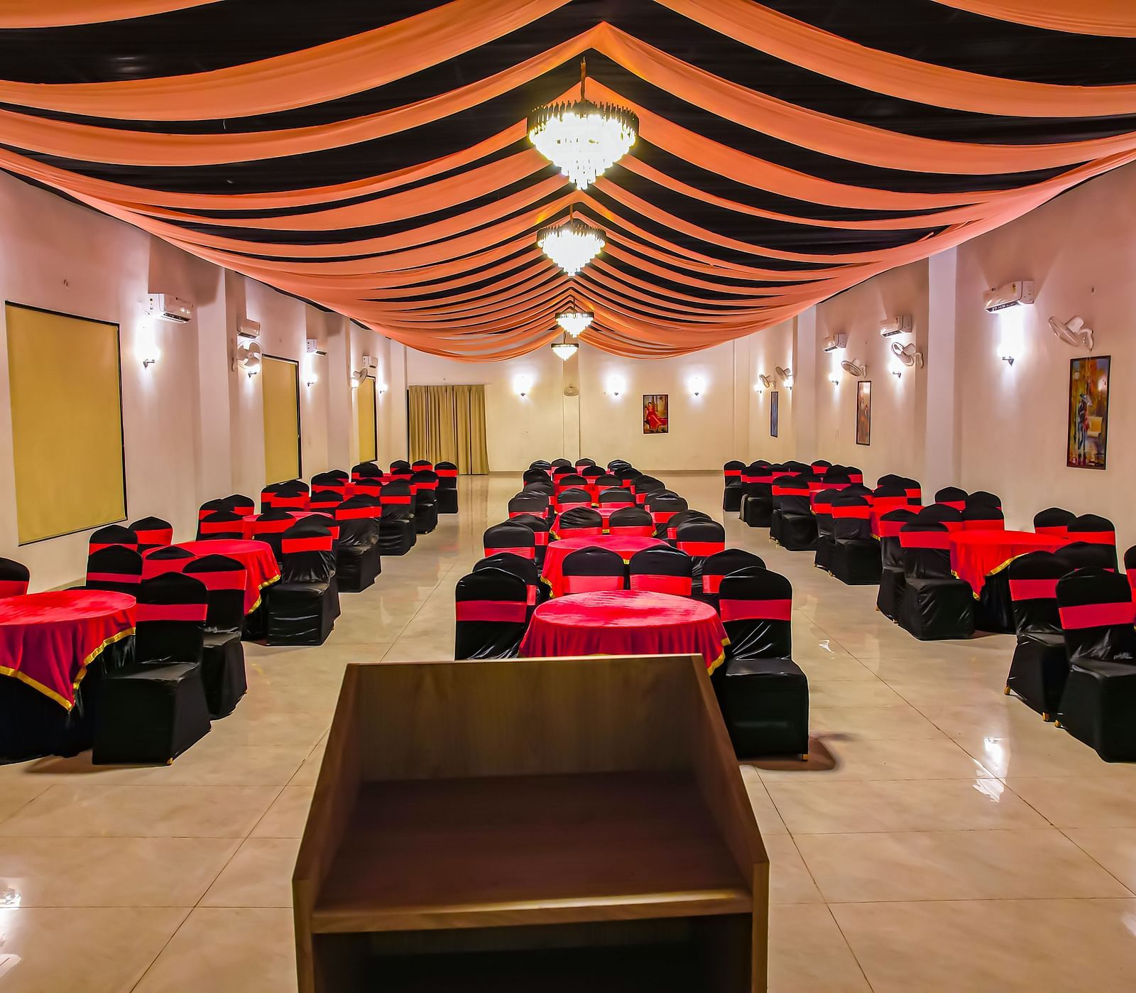 Another view of an empty banquet hall at Vedikant Resorts The Mallard Corbett displays rows of chairs and tables under a decorated ceiling.