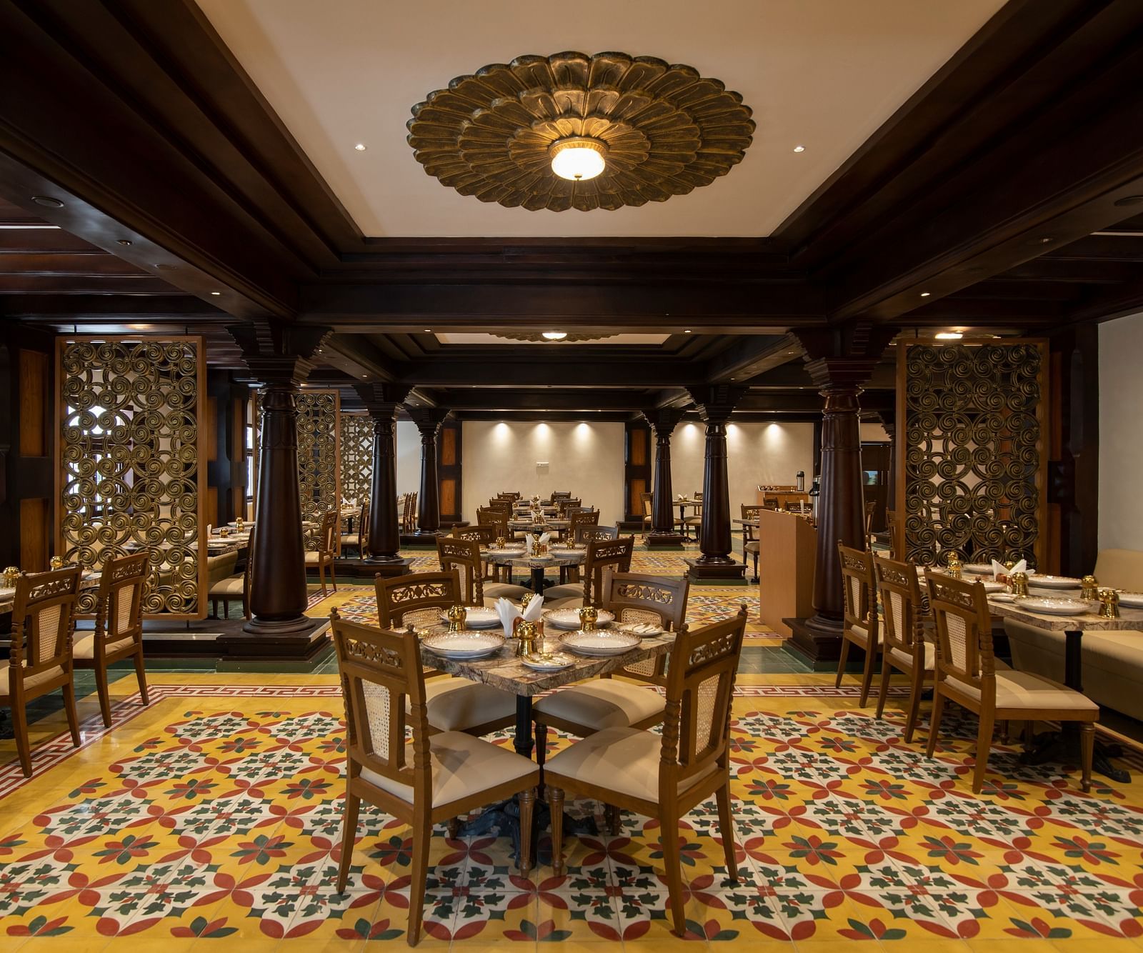 An image of classic-themed dining room with decorative wooden columns - The President Hotel, Kumara Park, Bangalore