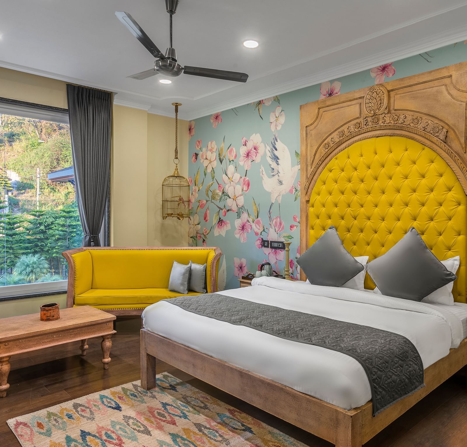 A cozy deluxe bedroom with a comfortable bed and colourful wall decor with a large window, captured in day light - atman, daramshala