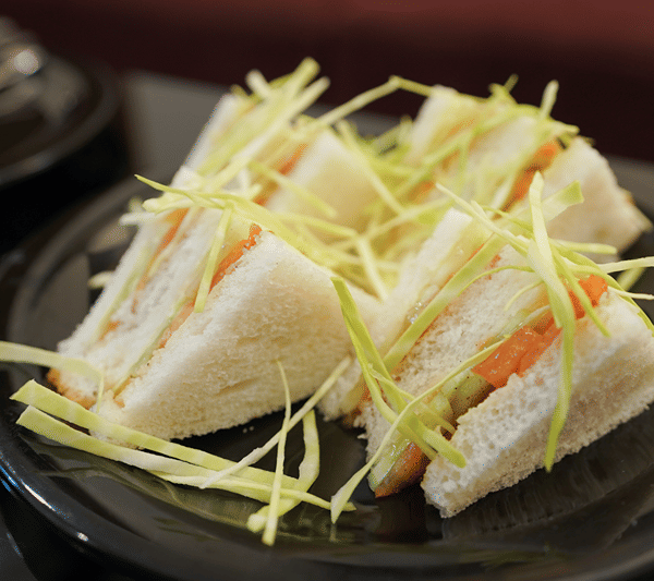 Vegetable sandwiches garnished with shredded cabbage.