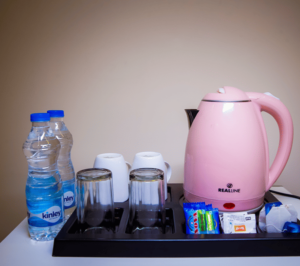 In-room tea and coffee station with an electric kettle and bottled water.