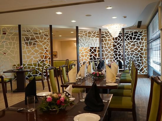 An image of a restaurant featuring  chairs, tables, and a chandelier light on top - Five Elements Hotels North Avenue, Delhi