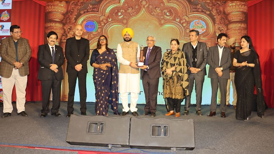 A group of people on a stage with ambient lighting and professional attire during an award ceremony