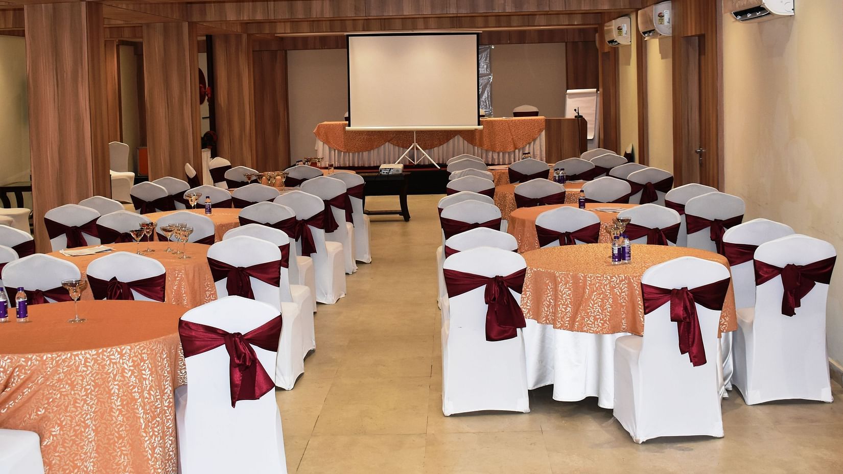 a banquet hall in The Orchid Hotel, Manali, decked with elaborate seating arrangements, projector and air-conditioner