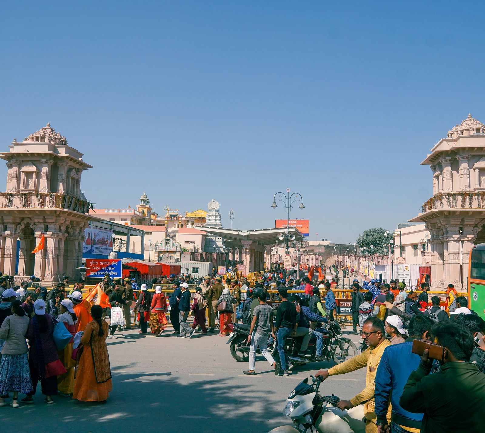 A bustling marketplace scene with people, vehicles, and traditional Indian architecture around