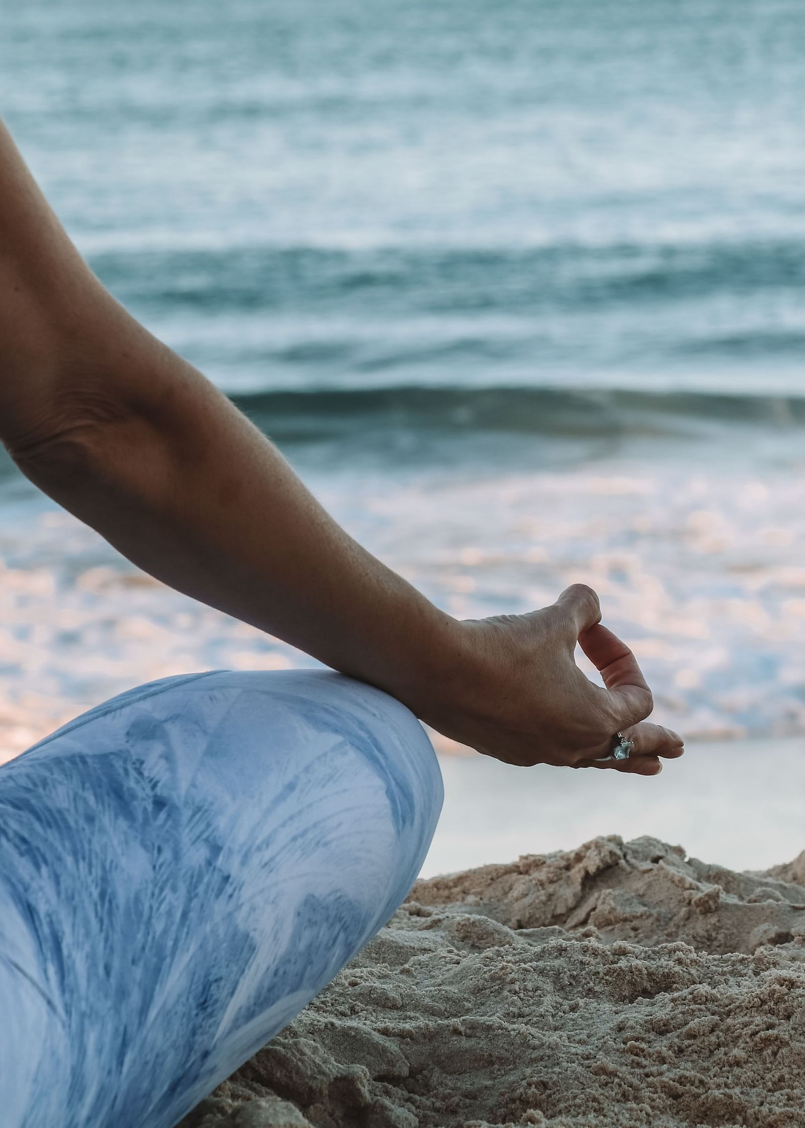 A woman meditating near a serene beach