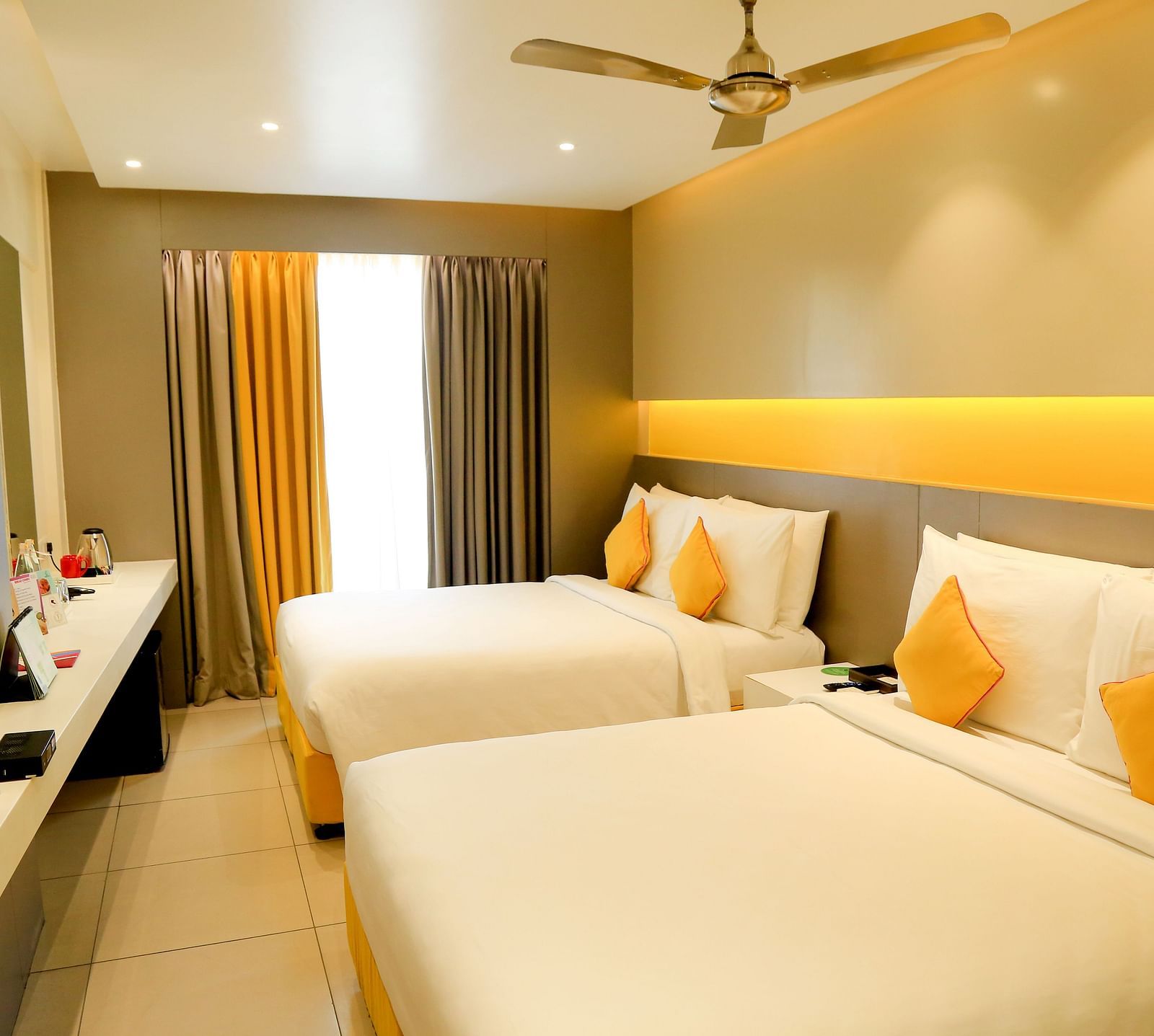  Spacious twin beds with headboards line the wall, large windows with curtains cover them