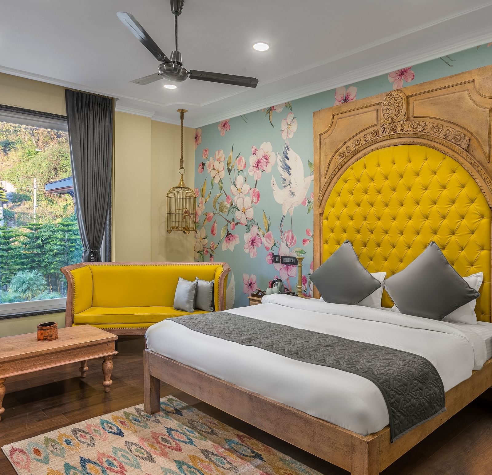 a bedroom with a large bed with a headrest and a sofa beside it - Atman, Dharamshala
