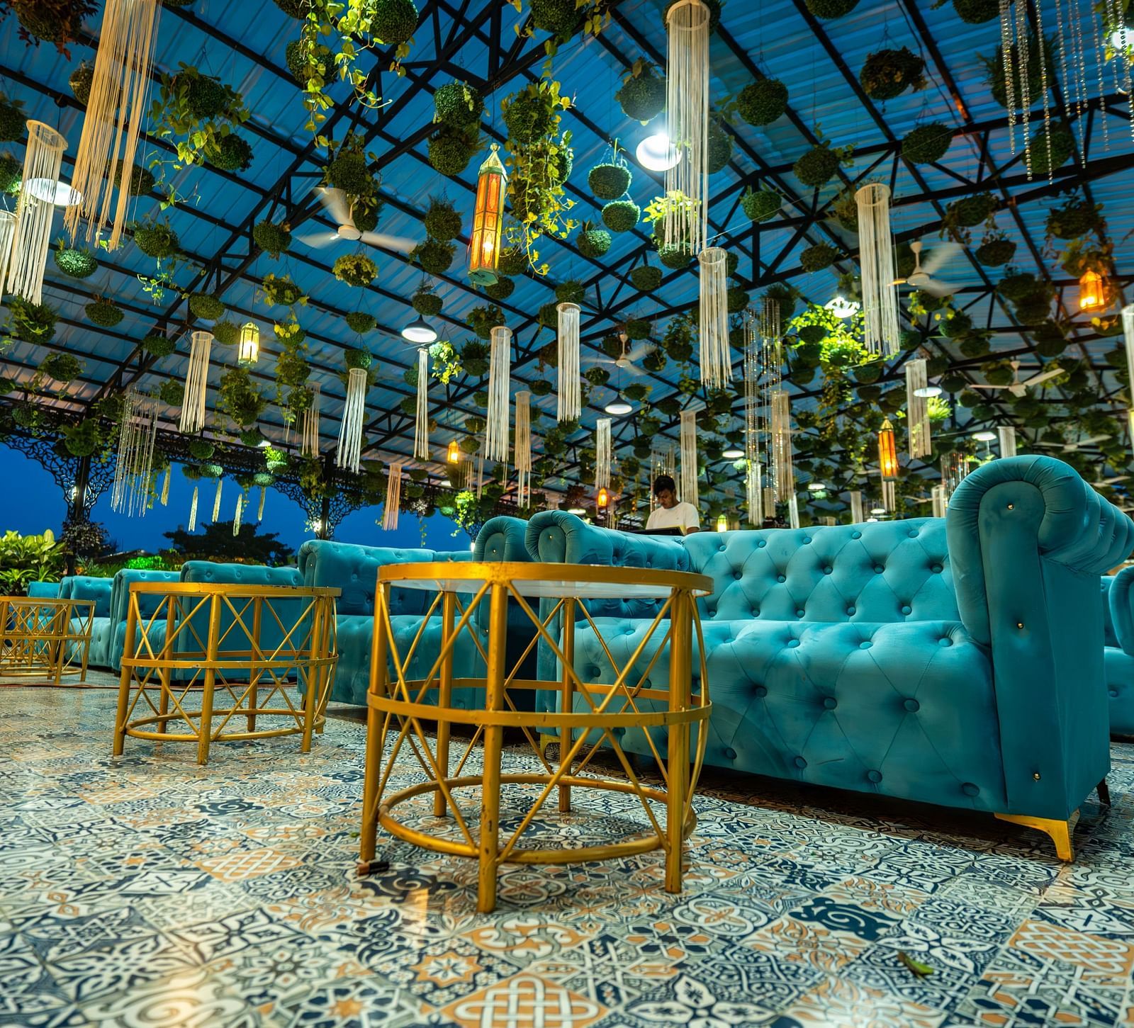 A gold coloured table and blue sofa at Mayfair Purnea