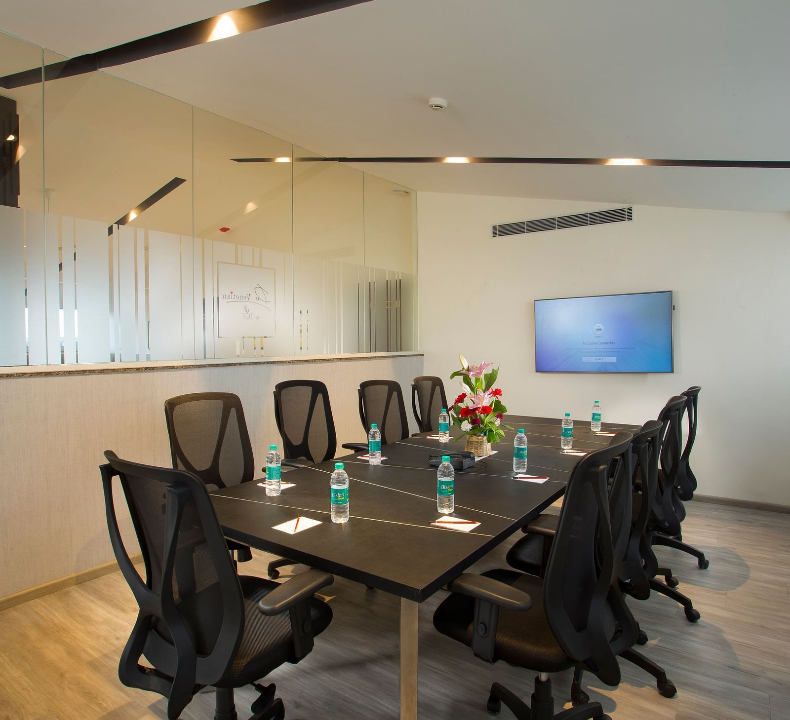Another angle of the conference room showing a glass partition and a whiteboard - De Venetian by TGI, Brookefield