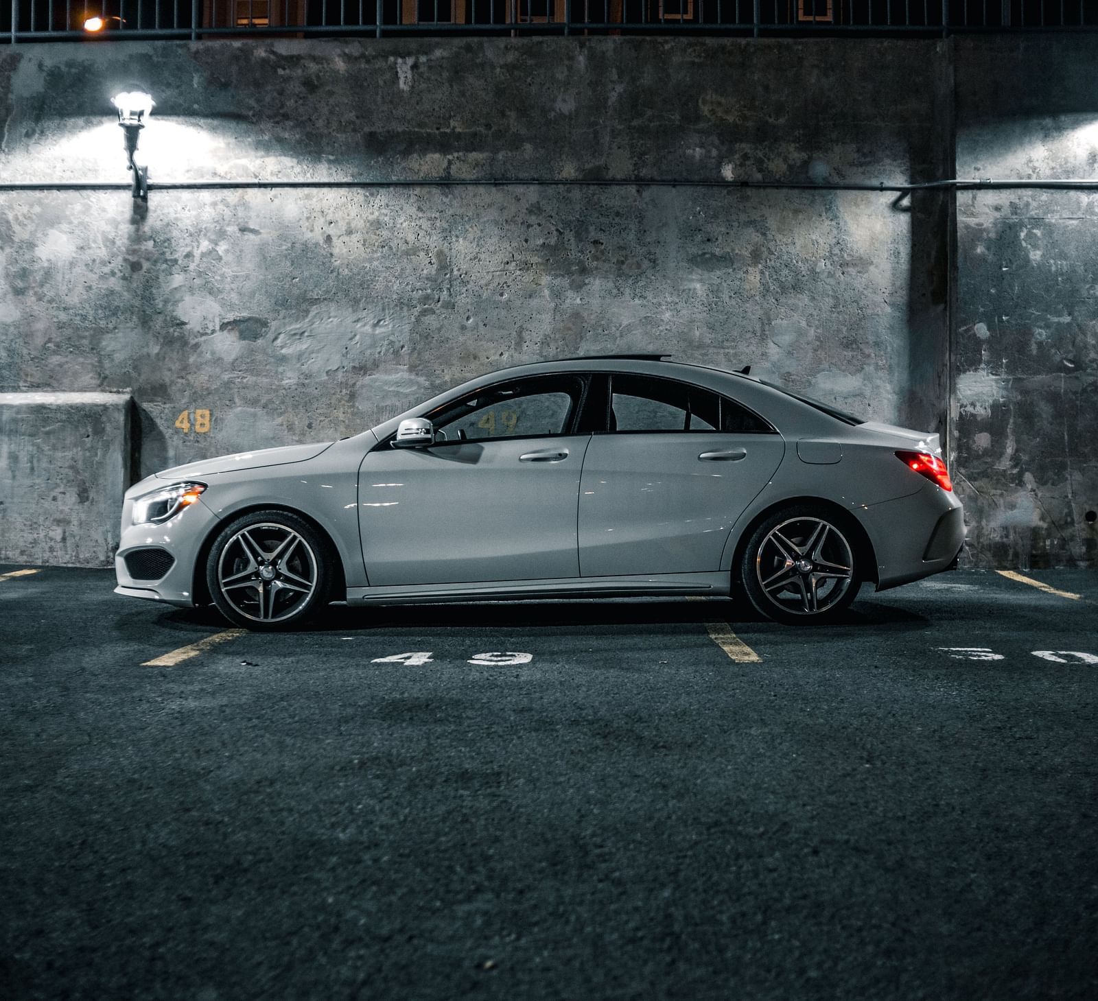 A silver sporty car parked in a well-lit underground parking lot