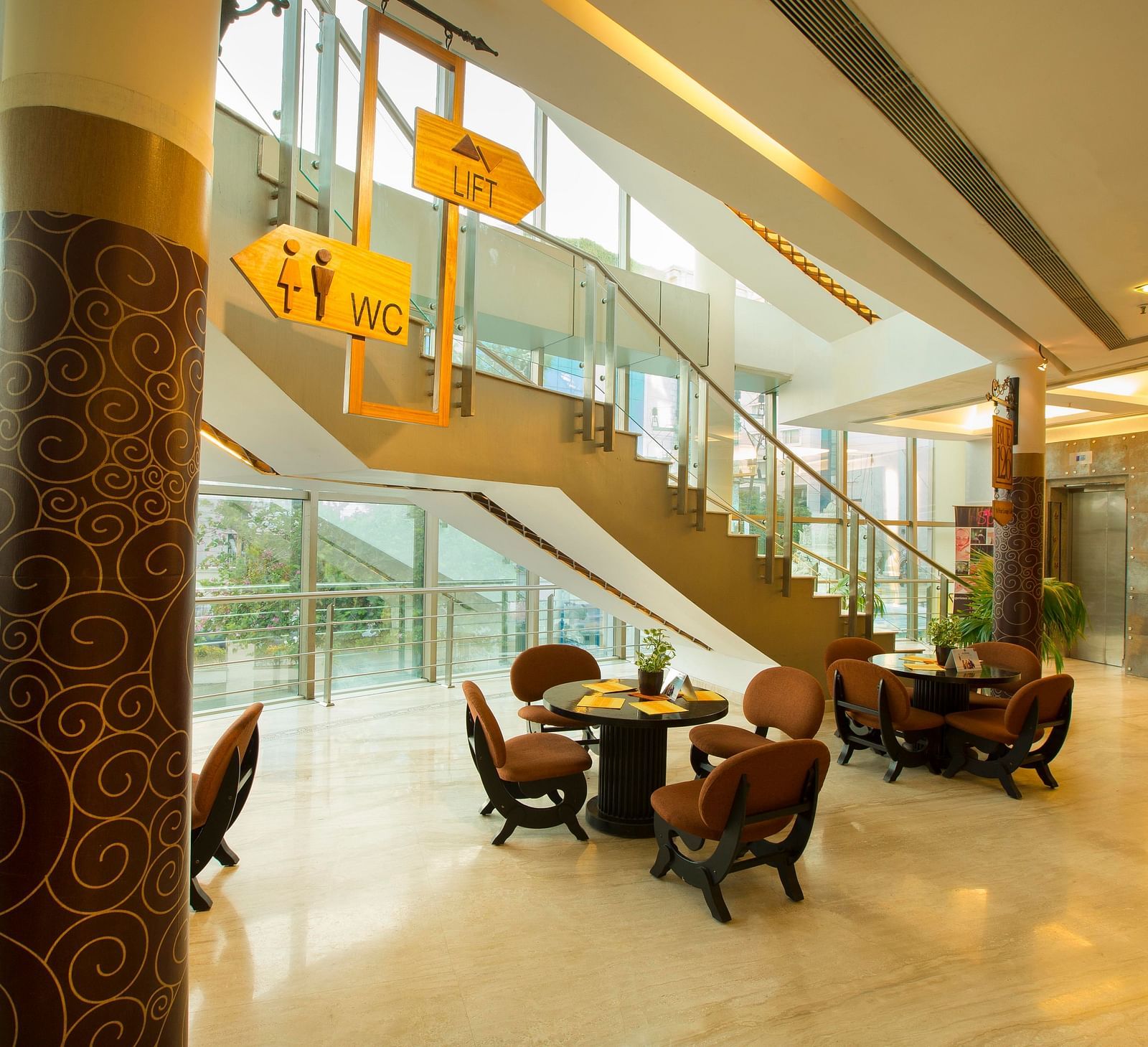 lobby of Hotel Atithi - TGI Grand, Pondicherry arrayed tables and chairs