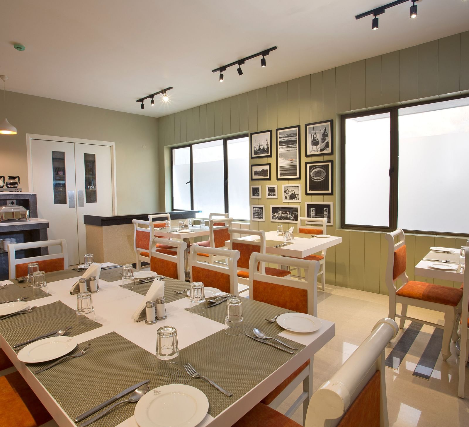 A contemporary dining area with set tables, modern lighting and black and white wall photographs  - Hotel Langford Keys by TGI, Shanti Nagar