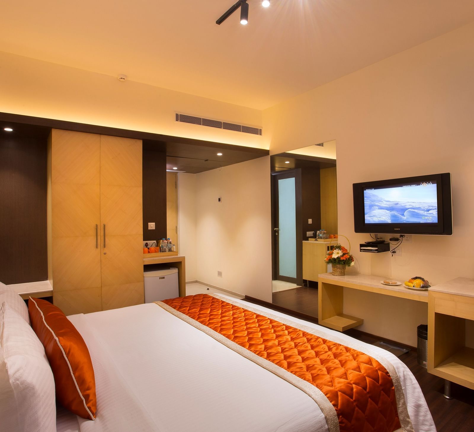 A comfortable hotel room with modern amenities, a large bed, a TV and a work desk with a chair - Hotel Langford Keys by TGI, Shanti Nagar