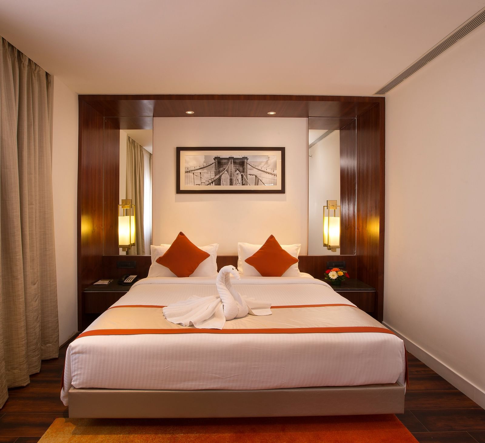 A hotel room featuring a large bed with white linens and red accents, a desk and a wall-mounted TV - Hotel Southend by TGI - Bommasandra, Bangalore