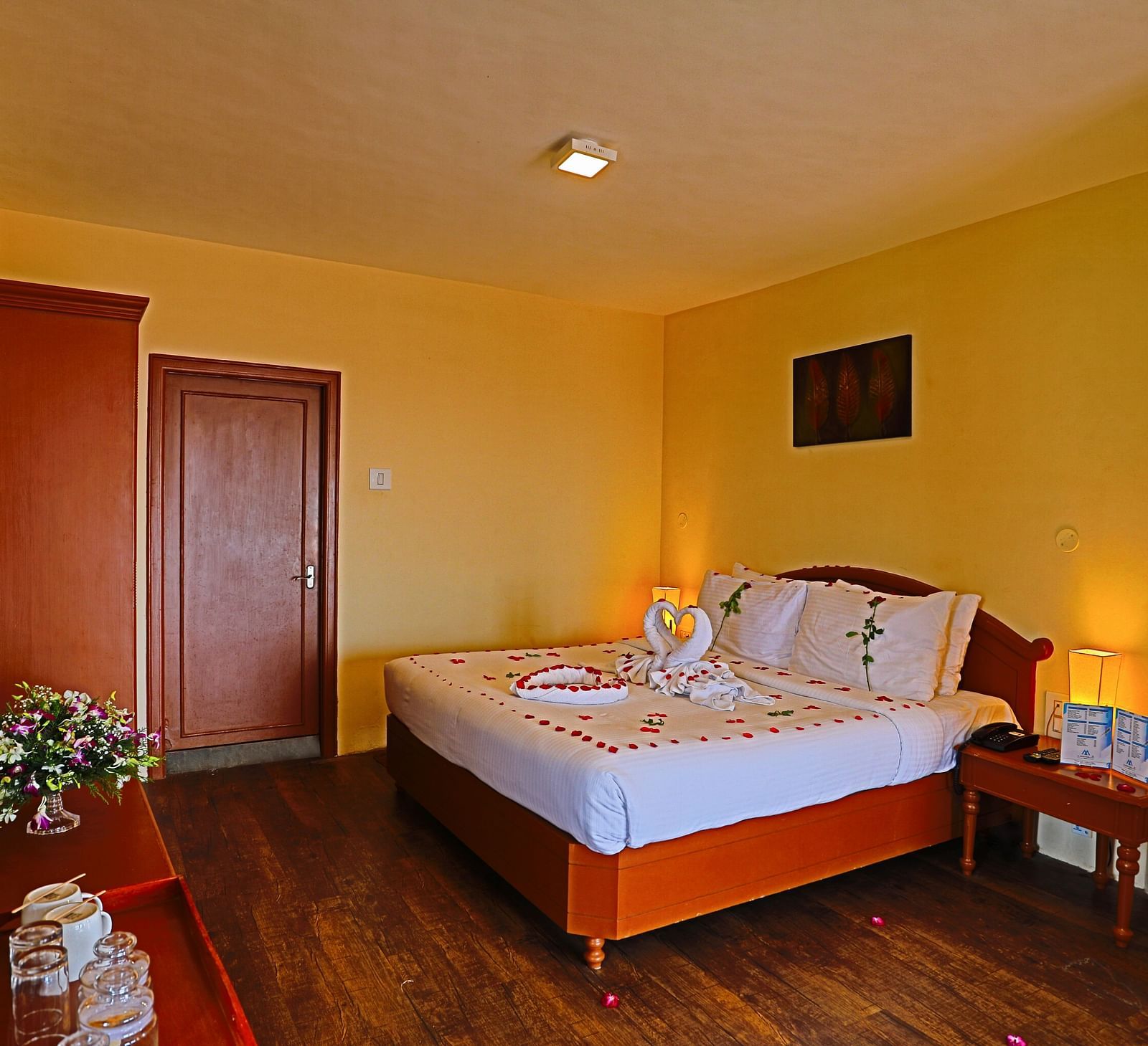 a plush white bed decked with flower petals at La Montana By TGI, Ooty
