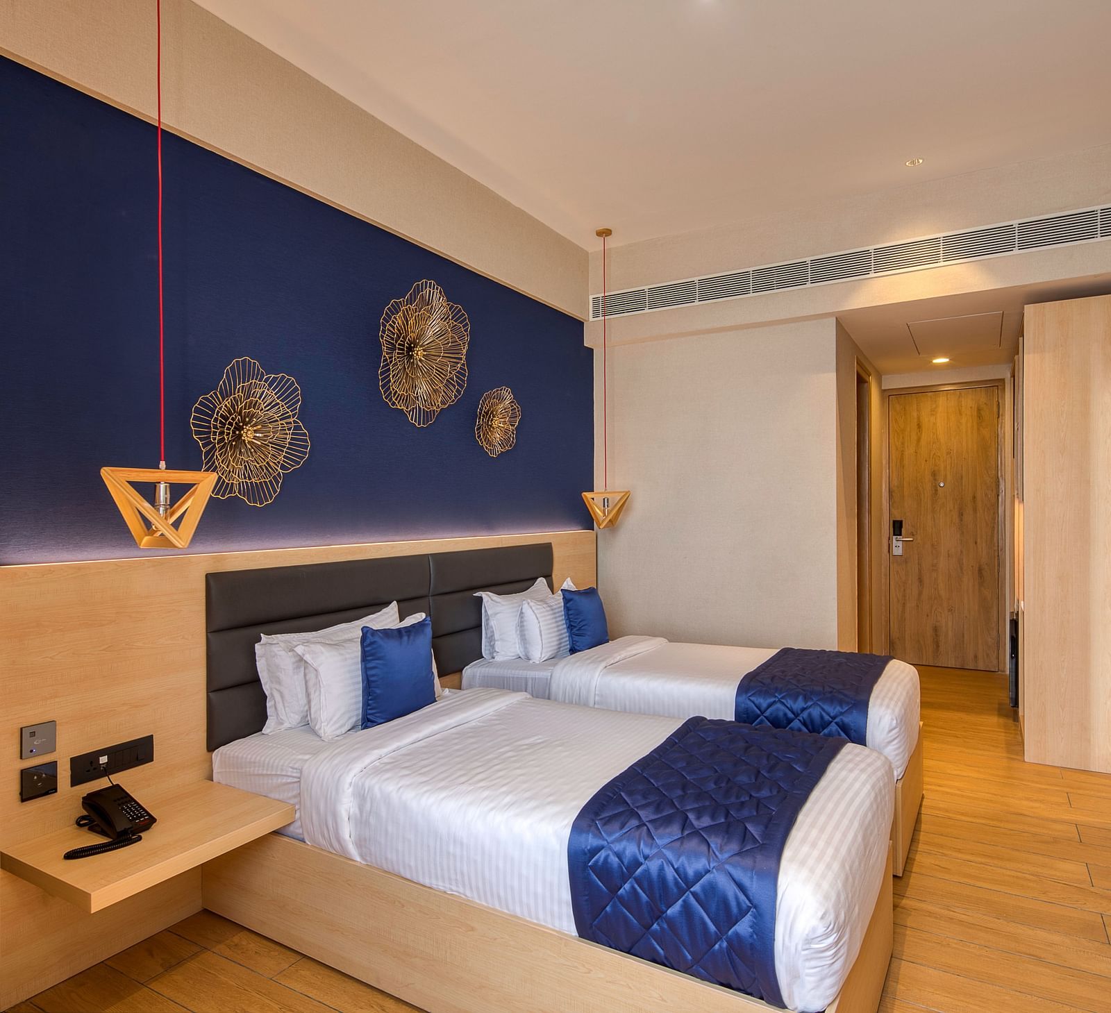 Twin beds with blue bedsheets and pillow covers at Executive Room at Le Foliage by TGI, Bangalore 2