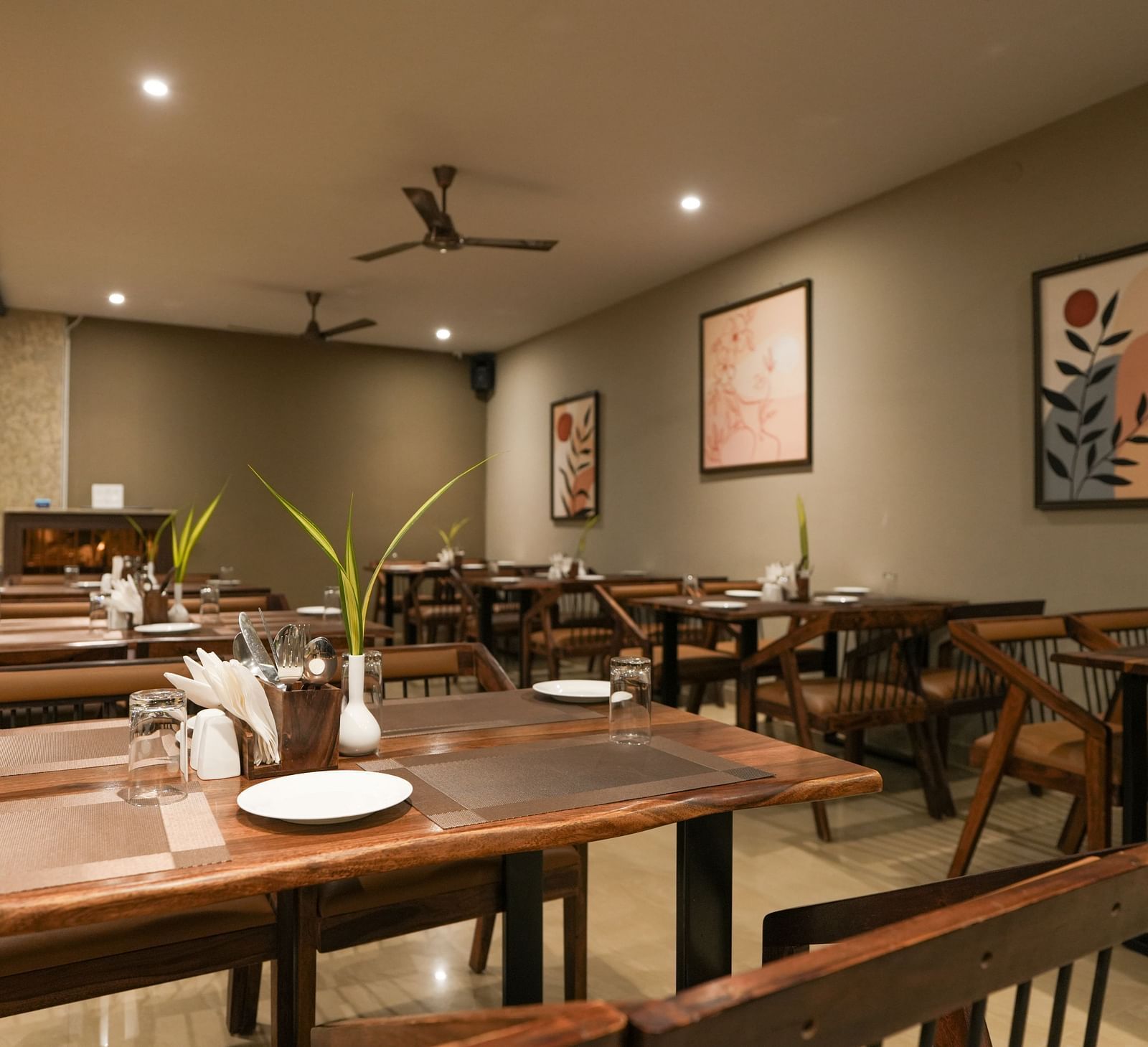 A restaurant view with ceiling fans, spotlights, and wooden dining furniture at TGI Livancia Hillside, JC Nagar, Mysore