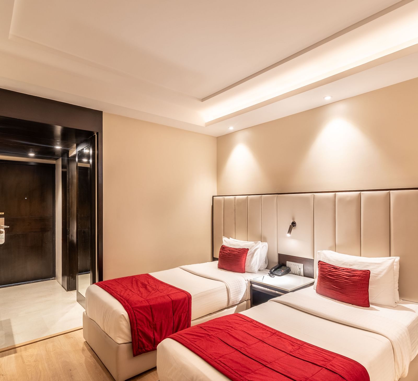 Superior Room with two beds featuring patterned bedding, a desk area, and lighting- TGI Grand Fortuna, Krishnagiri Main Road, Hosur