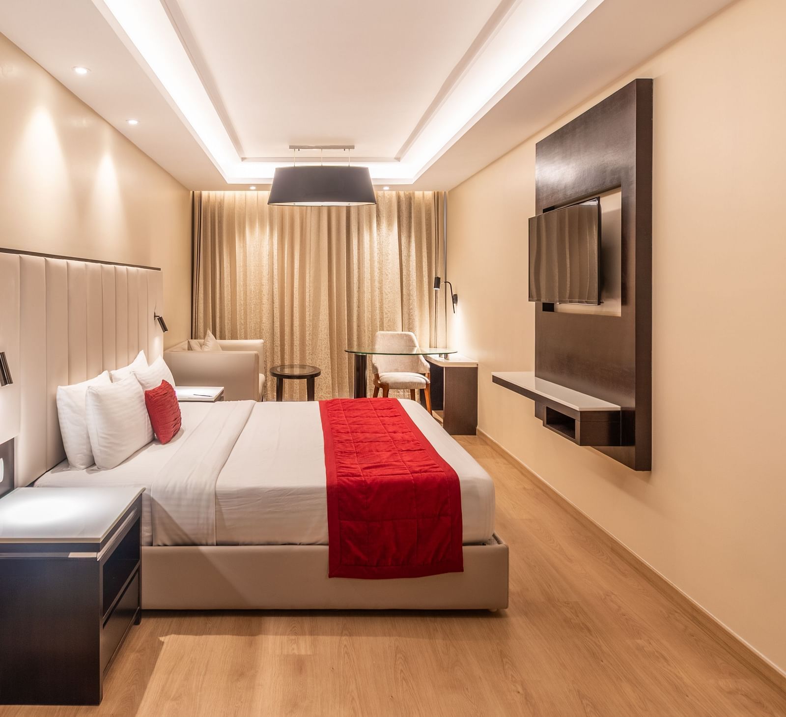 Cozy double room featuring a red runner and a flat-screen TV of Grand Suite- TGI Grand Fortuna, Krishnagiri Main Road, Hosur