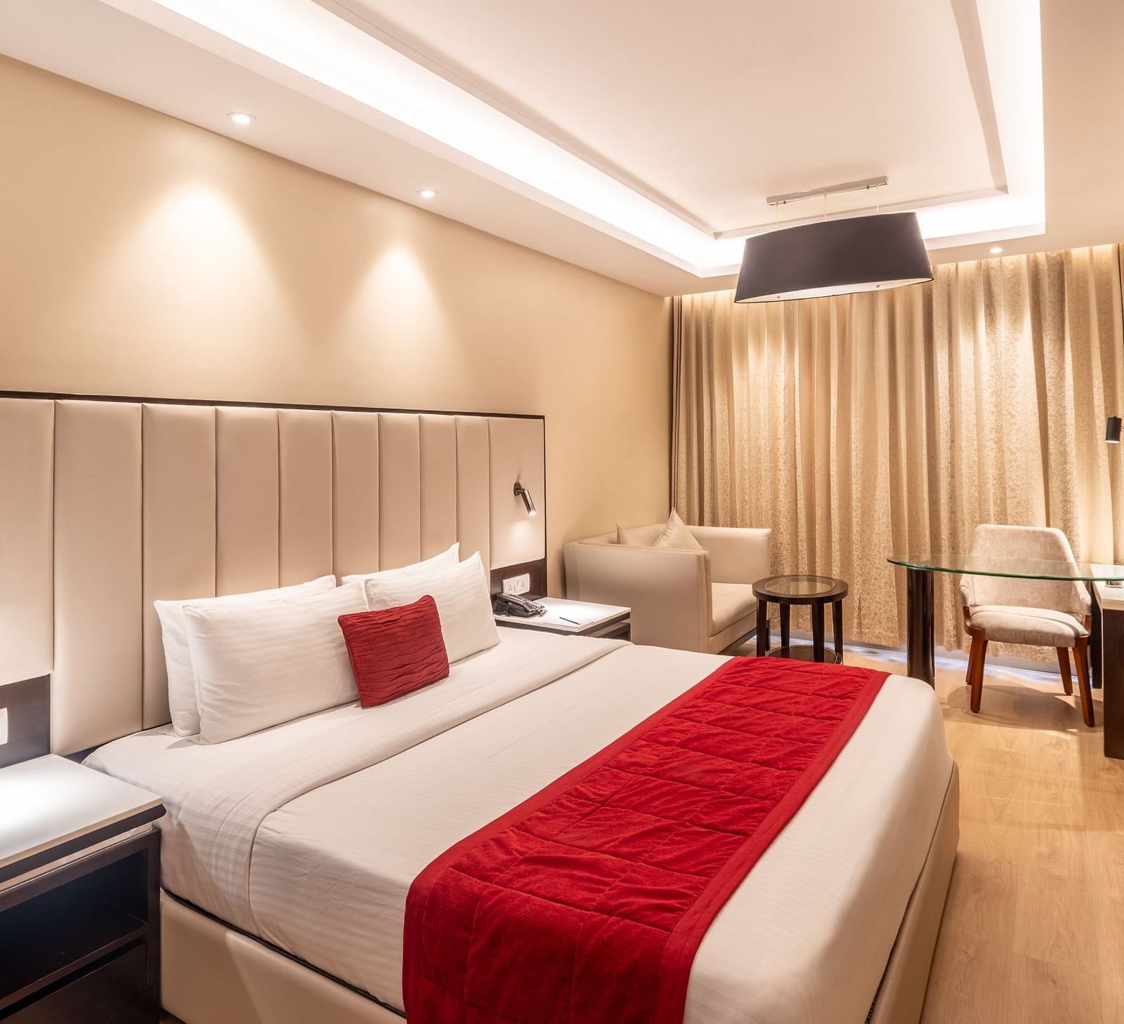 Grand Suite with a huge bed, red accents, and soft ambient lighting,- TGI Grand Fortuna, Krishnagiri Main Road, Hosur