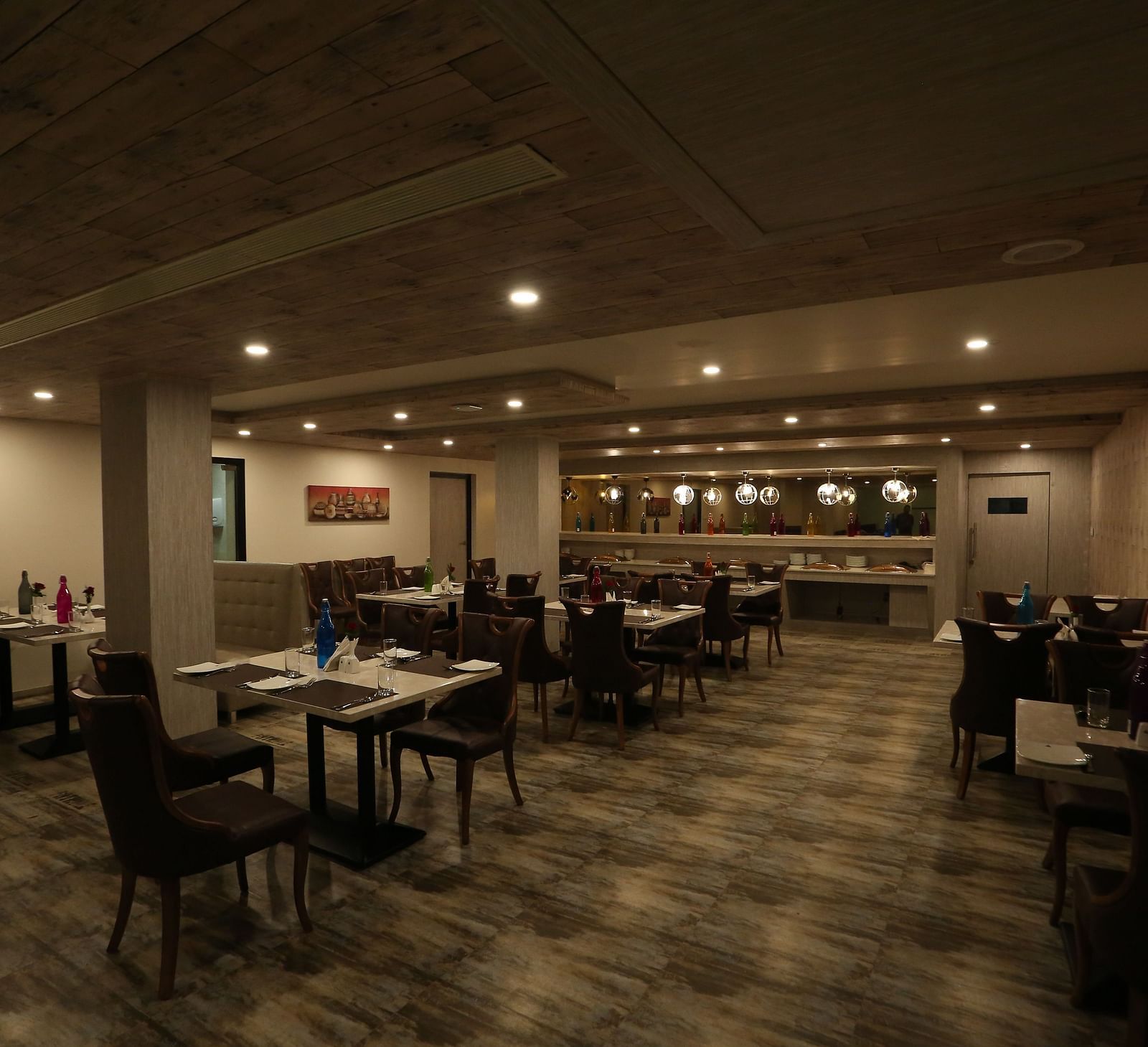 A restaurant with tables and chairs, designed with warm lighting and a cosy ambience - TGI SPS Grand, Coimbatore