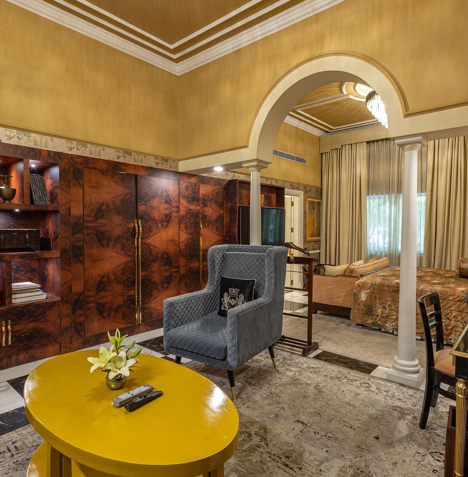 Executive Suite at The Claridges New Delhi, featuring a corner view of the room with a wall-mounted TV, cosy sofa, and a round table in front