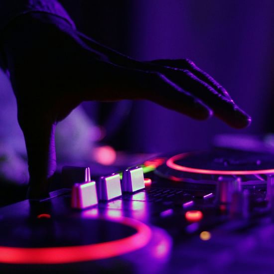 A DJ controlling the sound equipment with his thumb