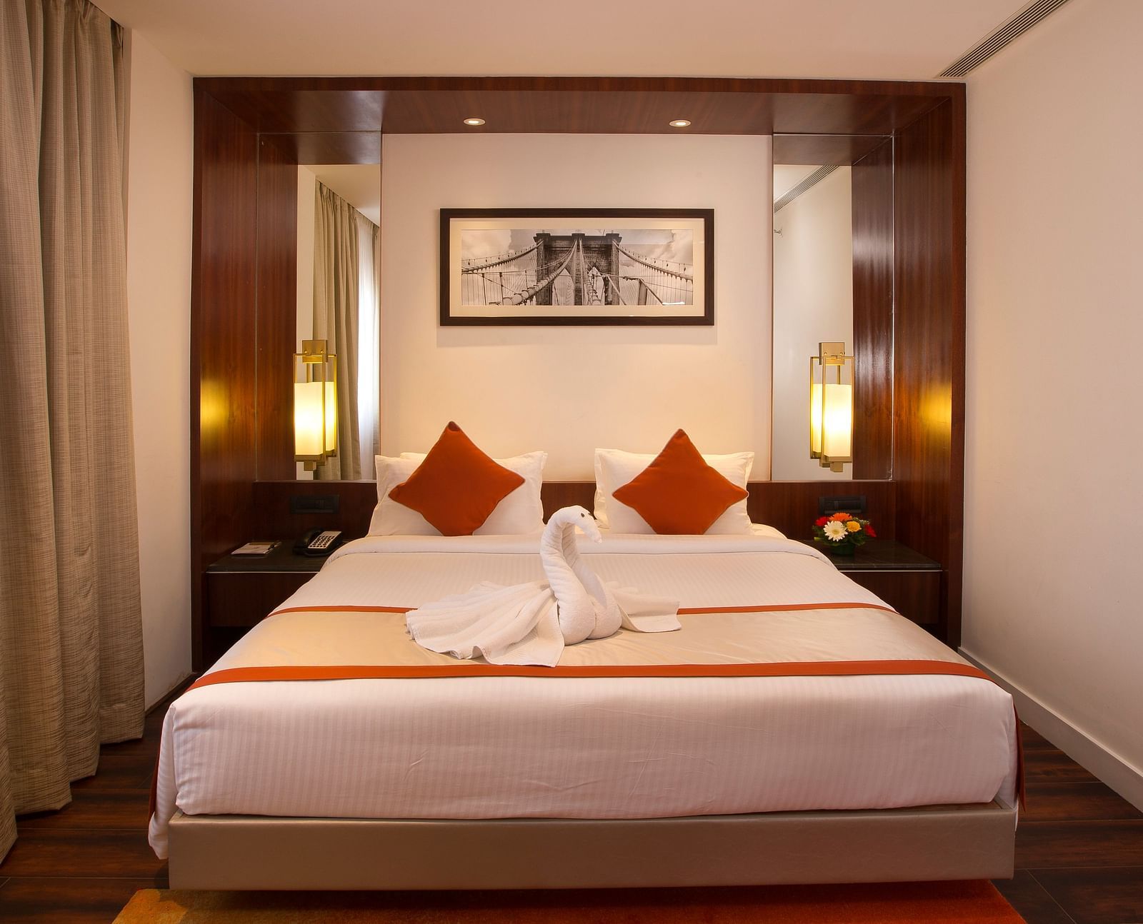 A hotel room featuring a large bed with white linens and red accents, a desk and a wall-mounted TV - Hotel Southend by TGI - Bommasandra, Bangalore