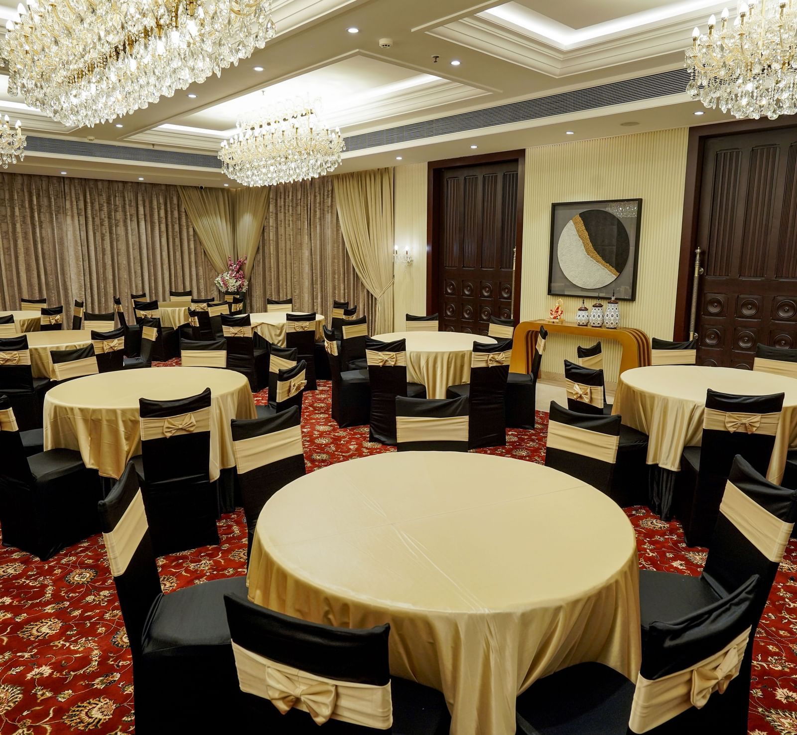 A full view shot of the Ballroom at M2 Square by Monday Premium with various round tables with golden table cloth spread over them.