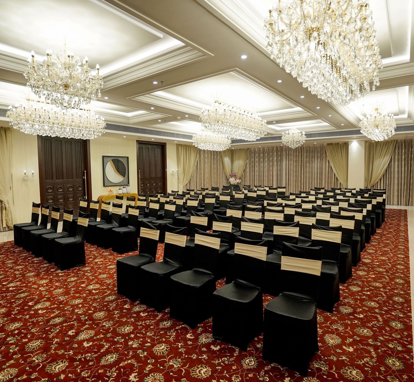 A wide angle shot of the Ballroom at M2 Square by Monday Premium with chairs arranged in a classroom setting with chandeliers hanging from the ceiling.