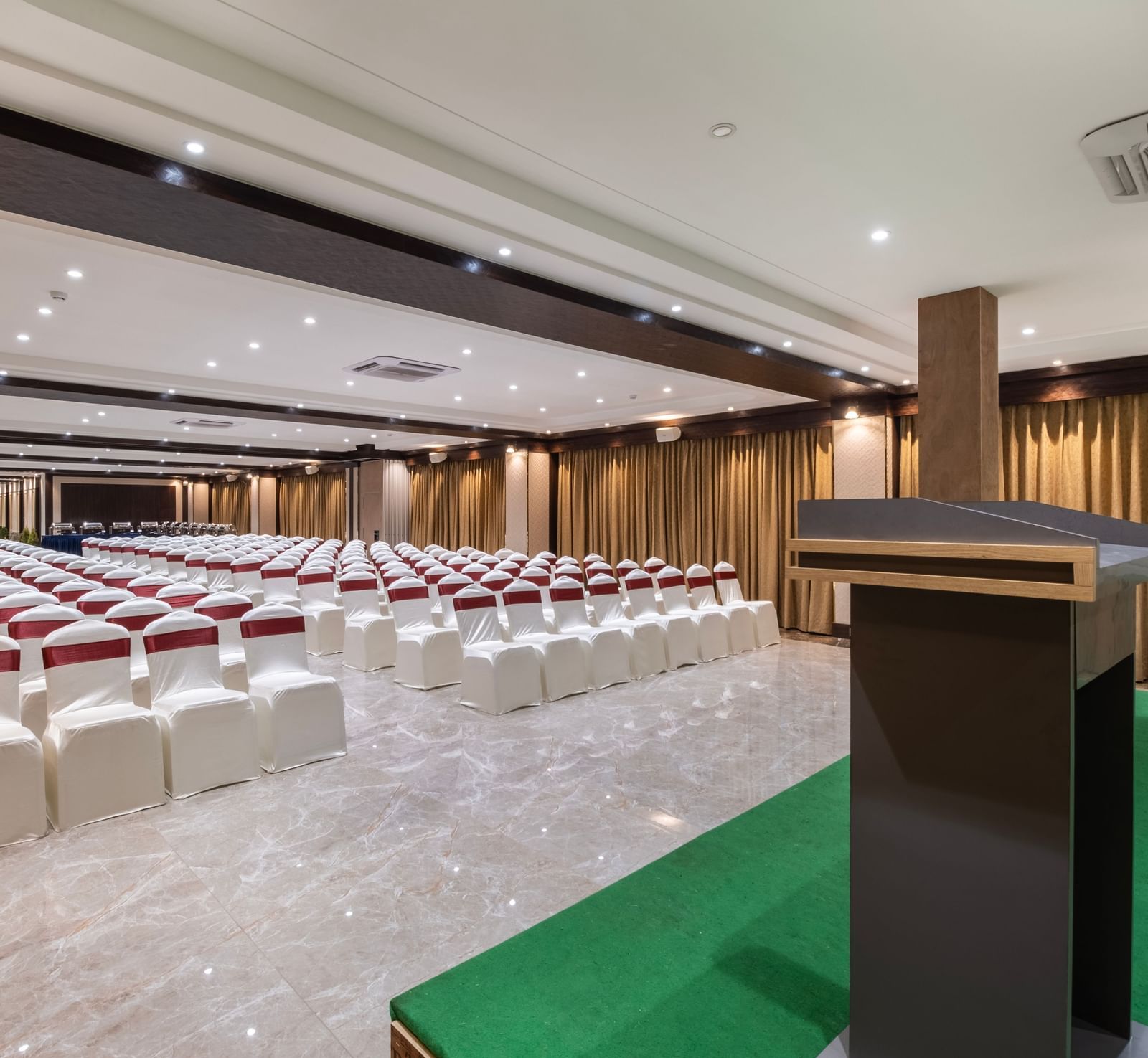 Conference hall at Monday Hotels Amalapuram Heights set with podium and theatre style seating.
