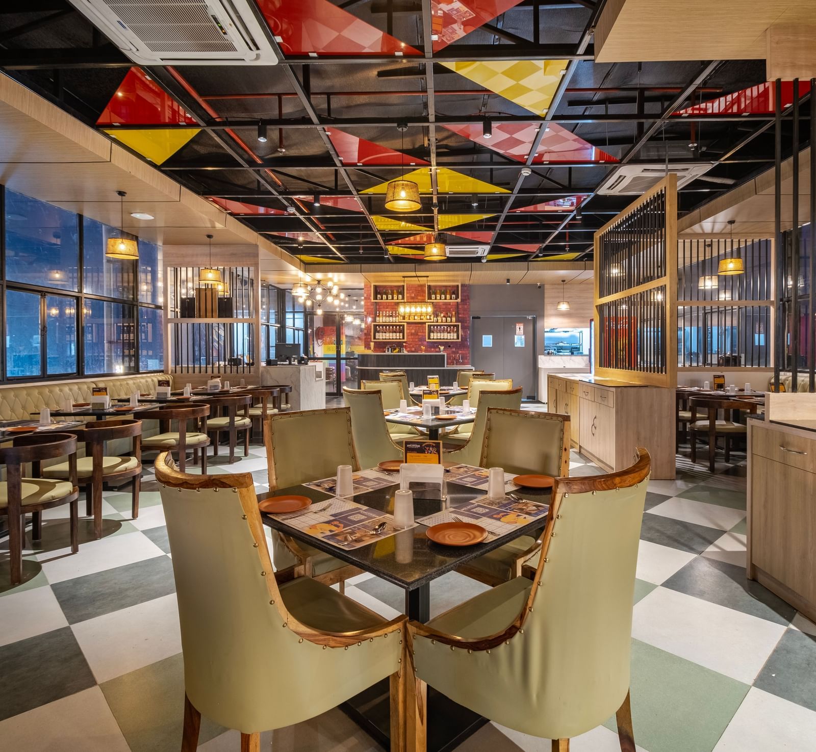Dining space at Monday Hotels Amalapuram Heights with elegant seating, colourful seating, and city views.