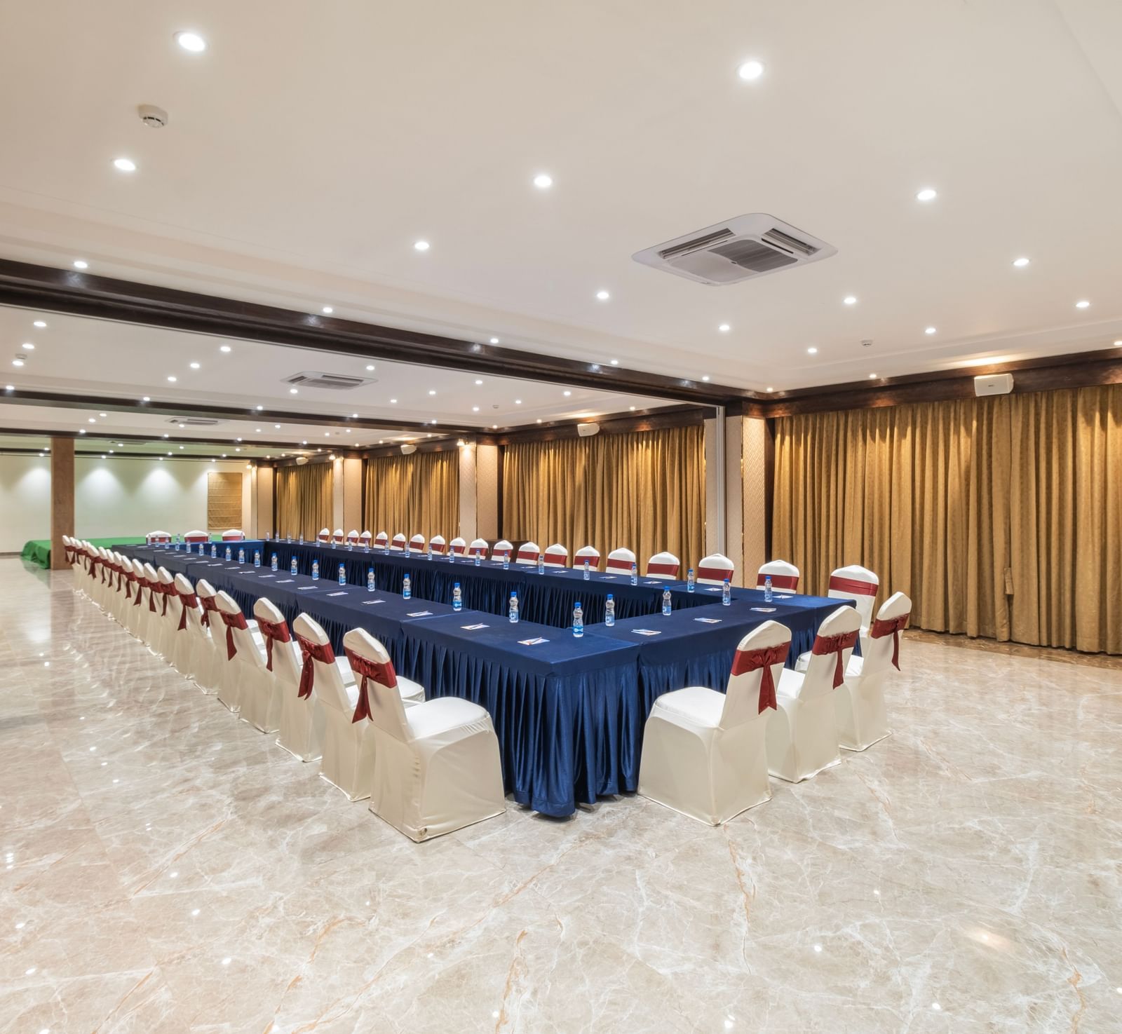 Banquet setup at Monday Hotels Amalapuram Heights with boardroom seating arrangement.