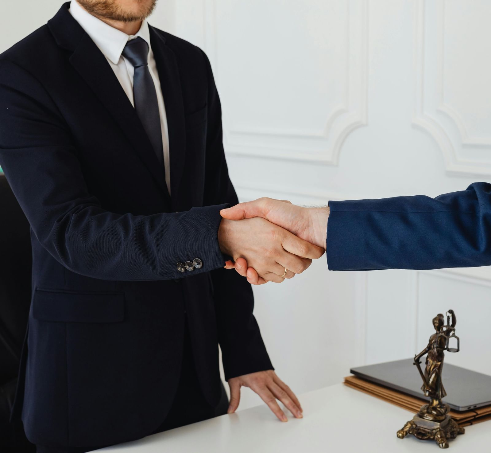 2 people dressed in business formals shaking their hands.